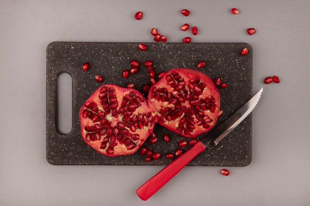 Free photo top view of fresh pomegranates on a black kitchen board with knife