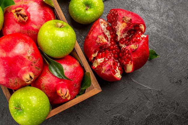 Top view fresh pomegranates with green apples on dark floor ripe fruit color