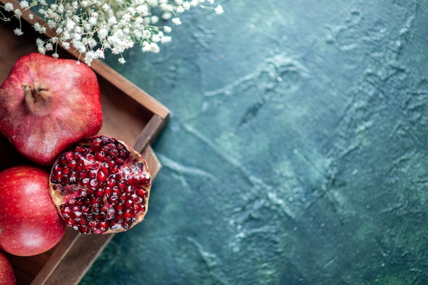 Top view fresh pomegranates on wood serving board on table copy place