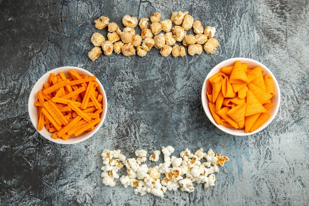 Vista dall'alto popcorn fresco con fette biscottate e patatine su una superficie chiara