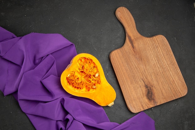 Top view of fresh pumpkin sliced fruit on dark background