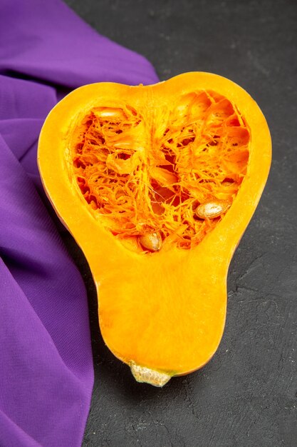 Top view of fresh pumpkin sliced fruit on dark background