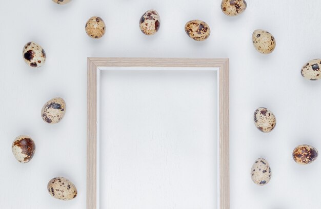 Free photo top view of fresh quail eggs with cream colored shells with brown splotches on a white background with copy space