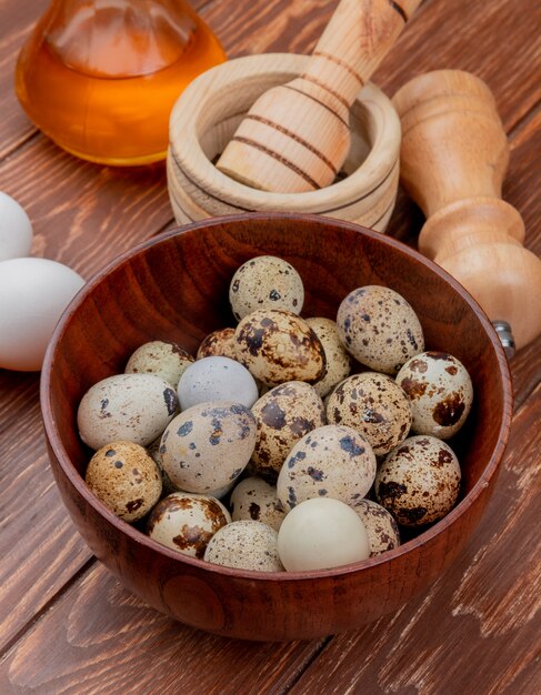 나무 배경에 식초와 흰 닭고기 달걀과 나무 그릇에 신선한 메 추 라 기 계란의 상위 뷰