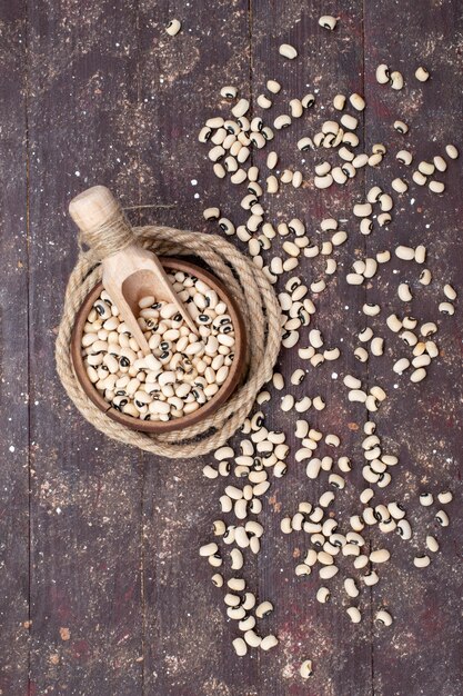 top view of fresh raw beans inside brown bowl and spread all over the brown, food raw bean haricot