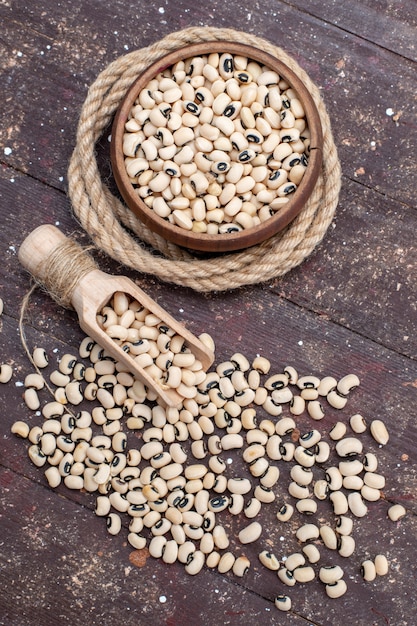 top view of fresh raw beans inside brown bowl with rope on brown, food raw bean haricot