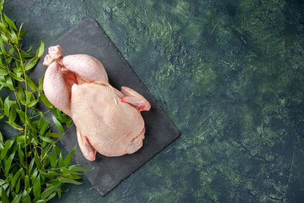 Вид сверху свежая сырая курица на темном фоне куриная еда фото животных еда цвет кухня мясо свободное пространство