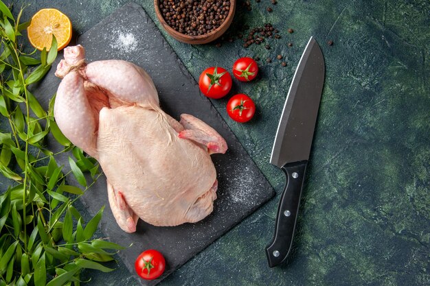 Top view fresh raw chicken with red tomatoes on dark background meal animal photo food color chicken meat