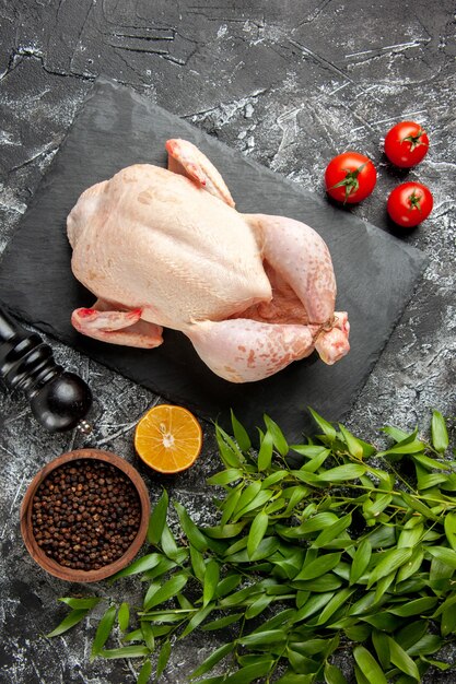 Top view fresh raw chicken with tomatoes on light-dark background kitchen meal animal photo meat color farm food