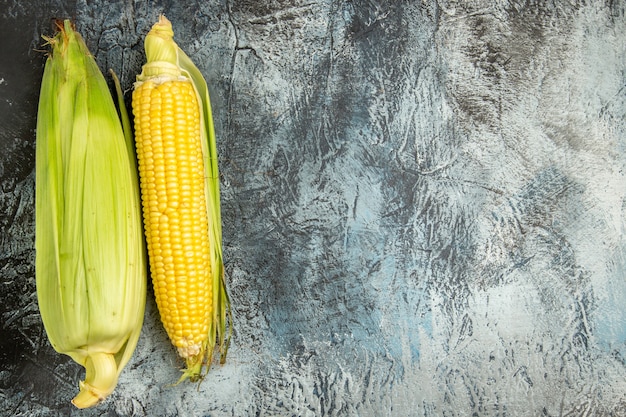 Top view fresh raw corn yellow plant on dark-light floor green photo plant