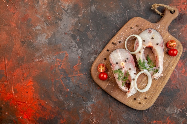 혼합 색상 표면에 신선한 생선과 고추 양파 채소 토마토의 상위 뷰