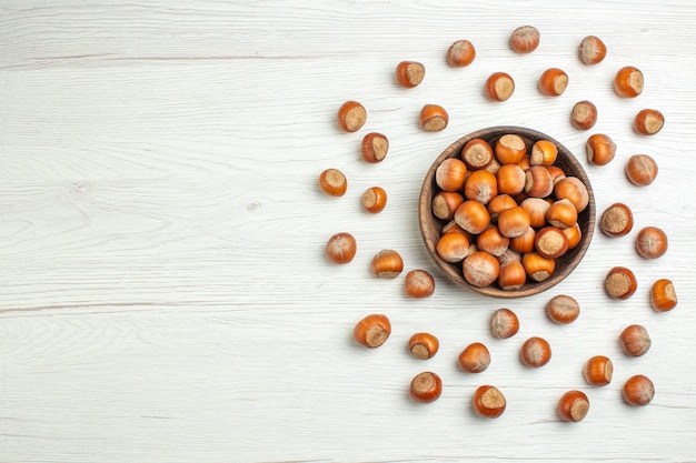 Free photo top view fresh raw hazelnuts on white desk