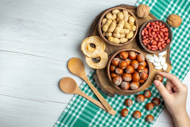 無料写真 上面図白いテーブルにピーナッツと新鮮な生のヘーゼルナッツスナックナッツ植物食品映画クルミピスタチオ