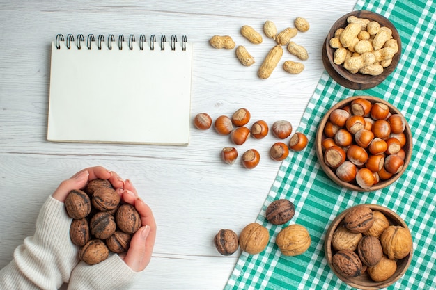 Free photo top view fresh raw hazelnuts with peanuts and walnuts on white table