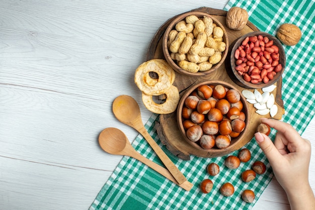 Top view fresh raw hazelnuts with peanuts on white table snack nut plant food movie walnut pistachios