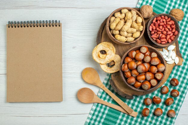 Free photo top view fresh raw hazelnuts with peanuts on a white table