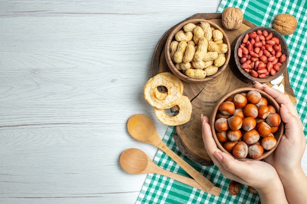 Top view fresh raw hazelnuts with peanuts on a white table