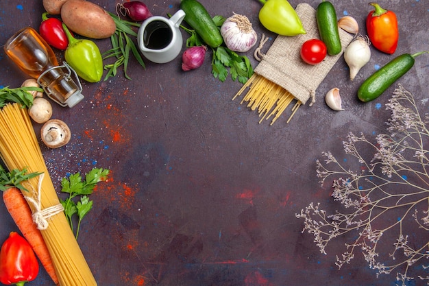 Вид сверху свежей сырой пасты с овощами на темной поверхности салатная еда здоровая овощная еда