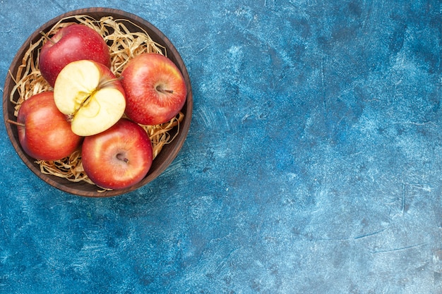 Top view fresh red apples inside plate on blue table photo ripe color tree fruit healthy life pear free space