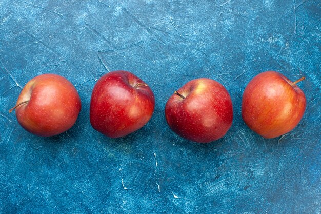 Free photo top view fresh red apples lined on blue table