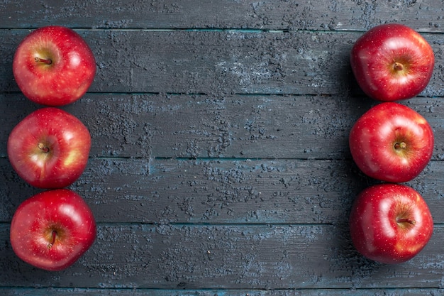 Вид сверху свежие красные яблоки спелые спелые фрукты на темно-синем столе цвет фруктов красный завод витамин свежий