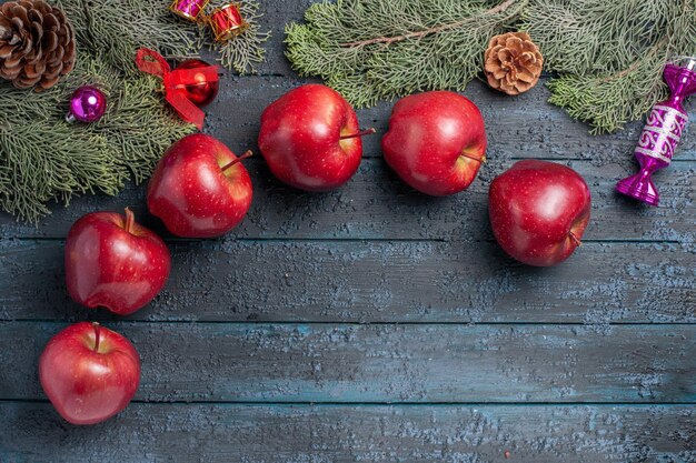 Вид сверху свежие красные яблоки, спелые спелые фрукты на темно-синем столе, много фруктов, цвет, витамин, свежие