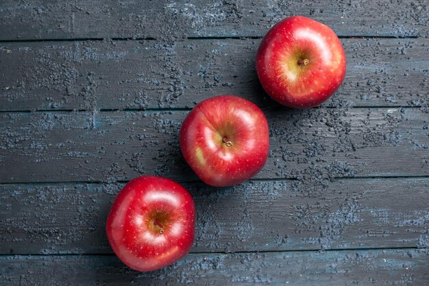 トップビュー新鮮な赤いリンゴ熟したまろやかな果物が紺色の机の上に並んでいます多くの果物の赤い新鮮な植物の色の木