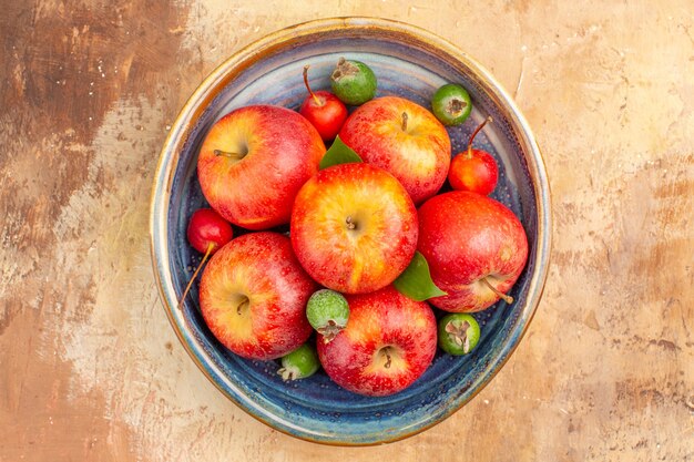 Top view fresh red apples with feijoas inside tray