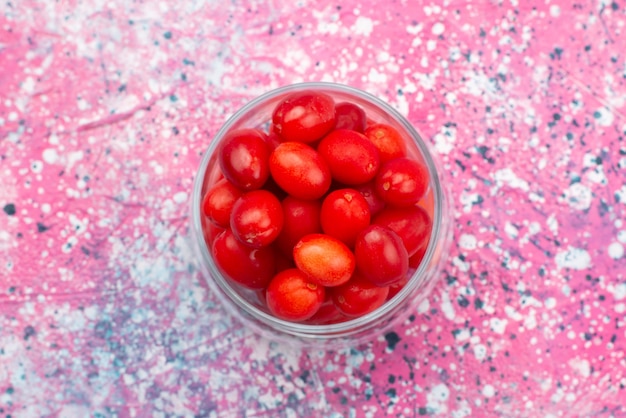 Top view fresh red fruits mellow sour and ripe inside transparent glass on the bright desk fruit berry fresh