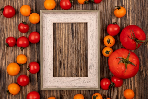 Top view of fresh red and orange cherry tomatoes isolated on a wooden wall with copy space