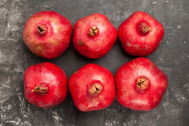 Top view fresh red pomegranates on dark background