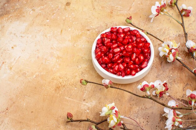 Top view fresh red pomegranates peeled inside plate on brown background