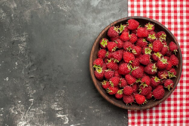 Top view fresh red raspberries inside plate on grey background