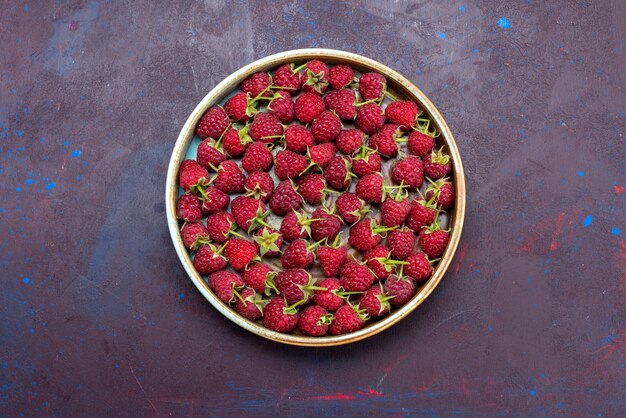 Top view fresh red raspberries ripe berries on dark-blue background fruit mellow summer food vitamine