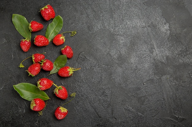 Foto gratuita fragole rosse fresche di vista superiore sul colore della frutta matura della bacca della tavola grigio scuro