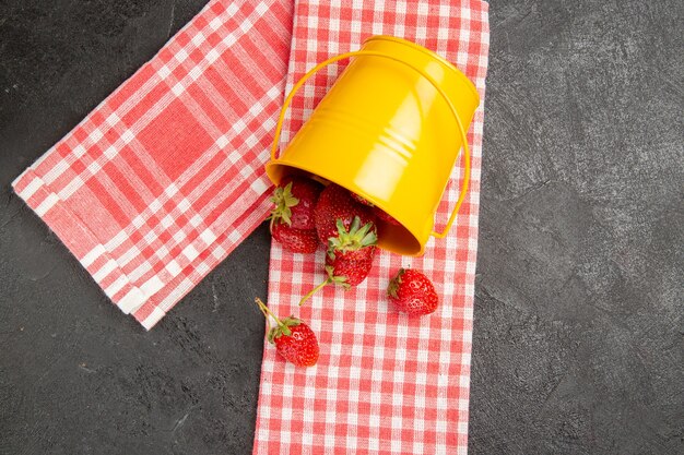 Free photo top view fresh red strawberries inside basket on the grey table color raspberry fruit