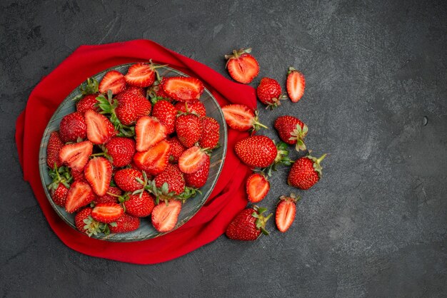 Top view fresh red strawberries inside plate on dark background