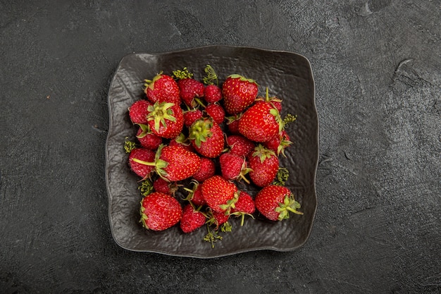 어두운 테이블 과일 베리에 접시 안에 상위 뷰 신선한 빨간 딸기