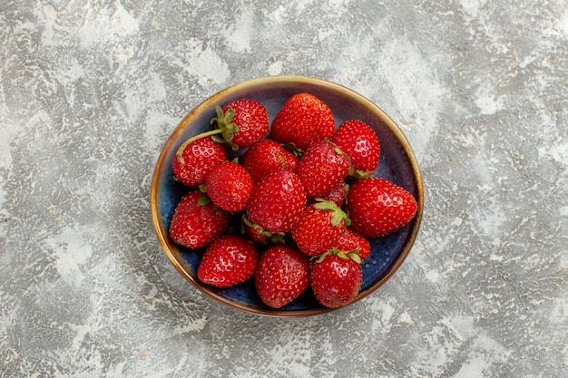 Top view fresh red strawberries inside plate on white background