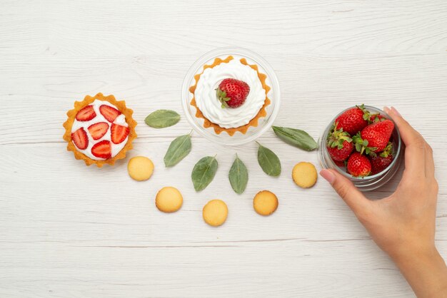 新鮮な赤いイチゴの上面図まろやかでおいしいベリーとケーキとクッキーライトグレーの机の上、フルーツベリーレッドフレッシュ
