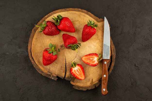 top view fresh red strawberries sliced mellow ripe on the brown desk and dark