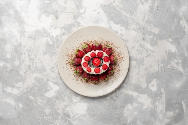 Бесплатное фото Вид сверху свежей красной клубники с тортом на белом пространстве