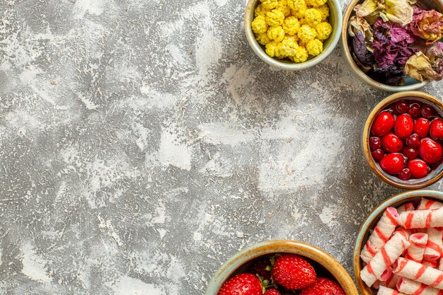 Top view fresh red strawberries with candies on white desk fruit sweet candy color