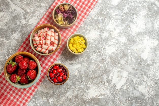 Top view fresh red strawberries with candies on the white surface berry fresh candy fruit