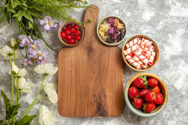 Top view fresh red strawberries with flowers on white surface berry fruits red candy