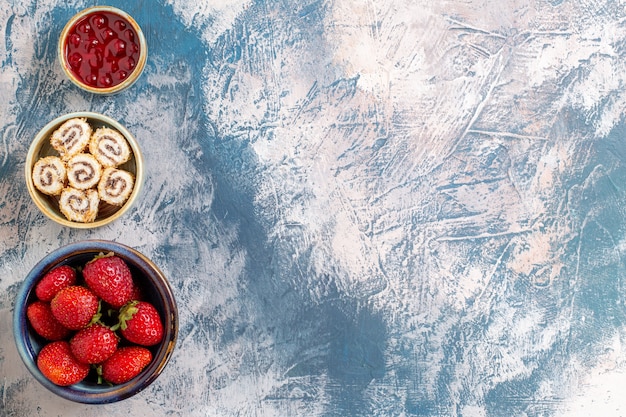 Top view of fresh red strawberries with jam on light surface