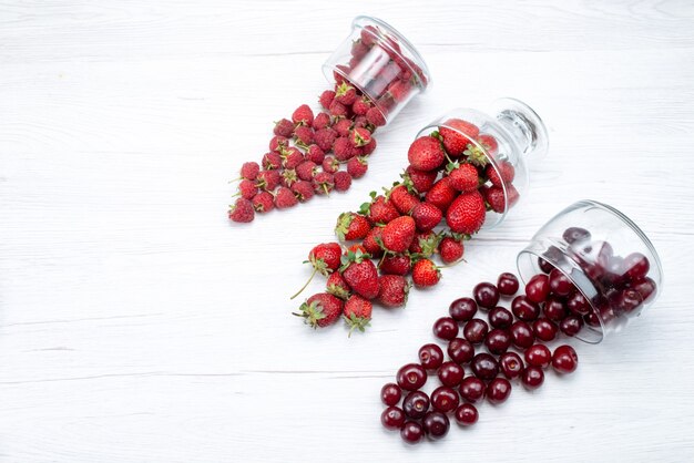 Top view of fresh red strawberries with sour cherries and raspberries on light, fresh fruit berry vitamine