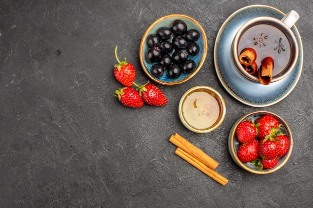 Top view fresh red strawberries with tea and olives on dark surface berry fresh fruit