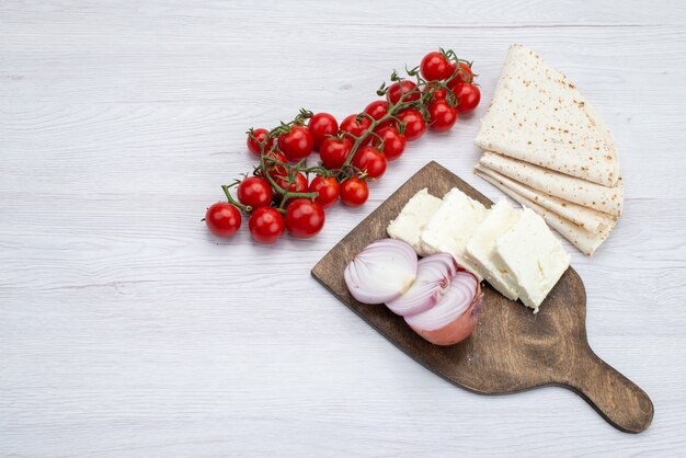 Top view fresh red tomatoes along with sliced white cheese onions and lavash on the white background food meal lunch photo vegetable