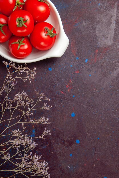 Top view of fresh red tomatoes ripe vegetables inside plate on black